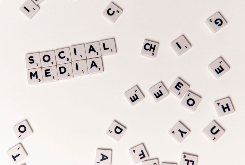 Scrabble tiles spelling 'Social Media' on a white background, symbolizing digital communication.